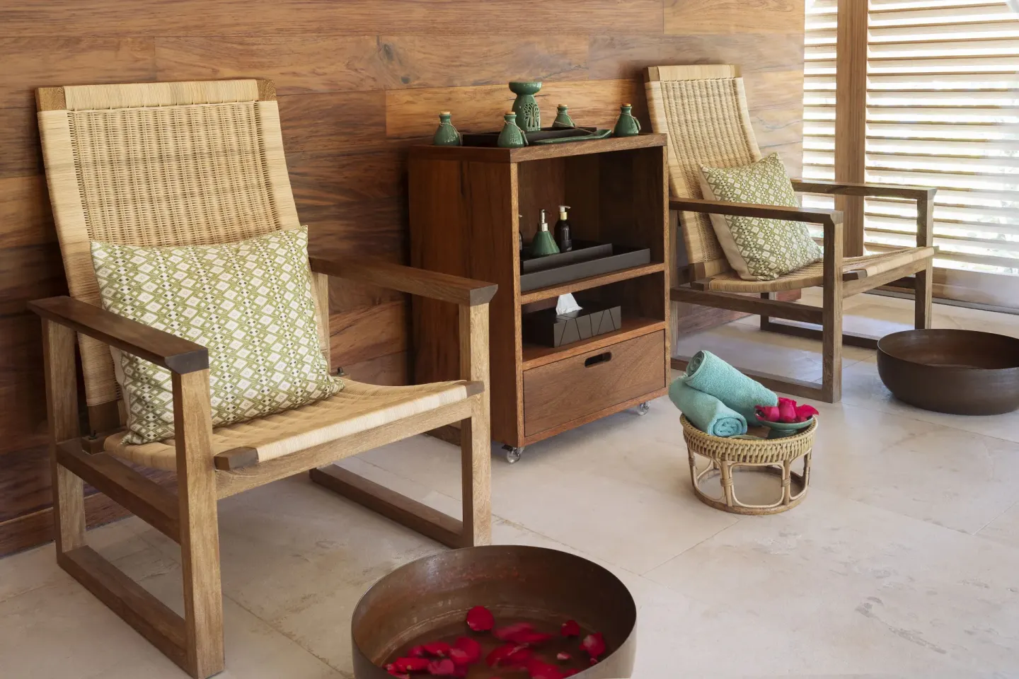 Spa seating area with woven chairs and flower foot bowls at Banyan Tree Mayakoba.