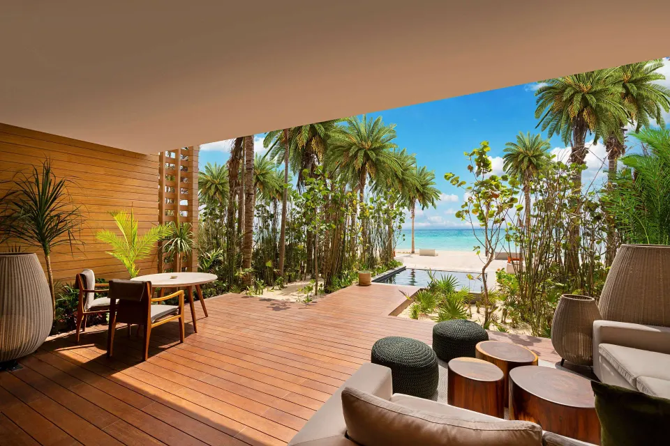 Beachfront Lanai Pool Suite terrace at Banyan Tree Mayakoba with seating, pool, palms, and beach view.