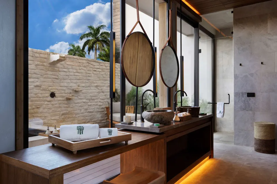 Beachfront Terrace Pool Suite bathroom vanity and outdoor view at Banyan Tree Mayakoba.