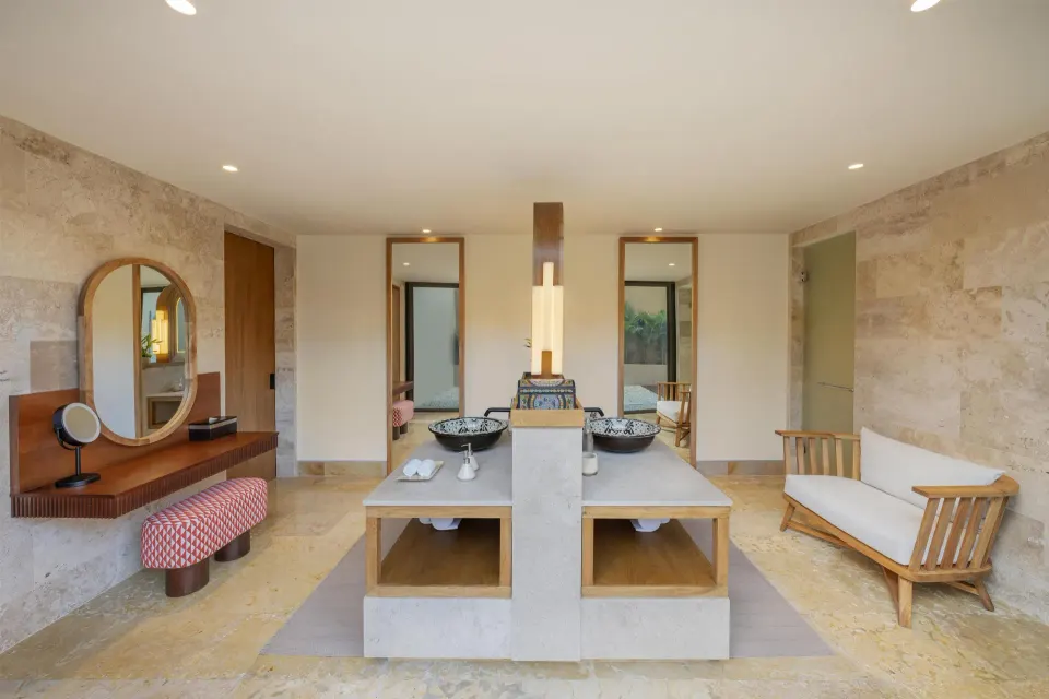 Spacious bathroom vanity with twin sinks and lounge bench at Banyan Tree Mayakoba.