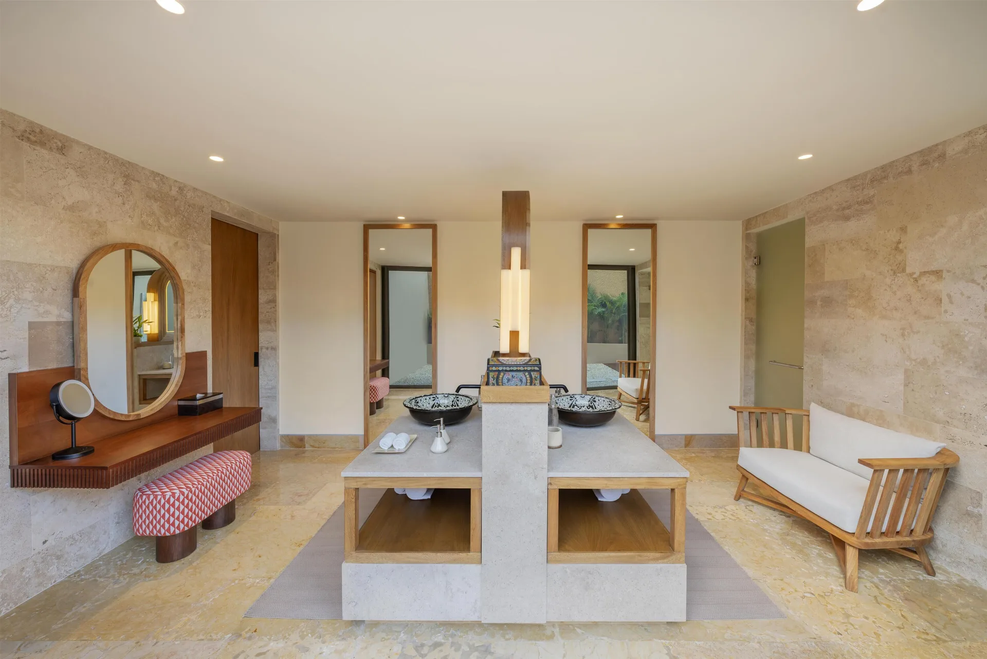 Spacious bathroom vanity with twin sinks and lounge bench at Banyan Tree Mayakoba.