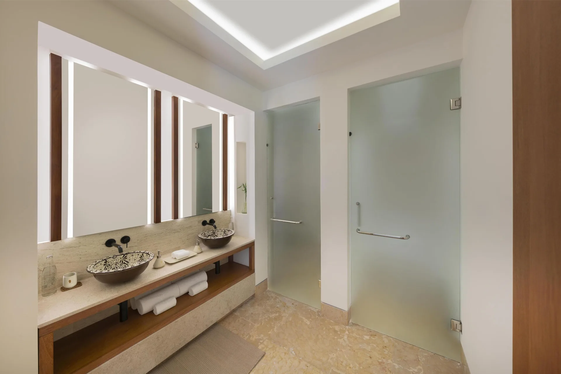 Double vanity bathroom with frosted glass doors at Banyan Tree Mayakoba.
