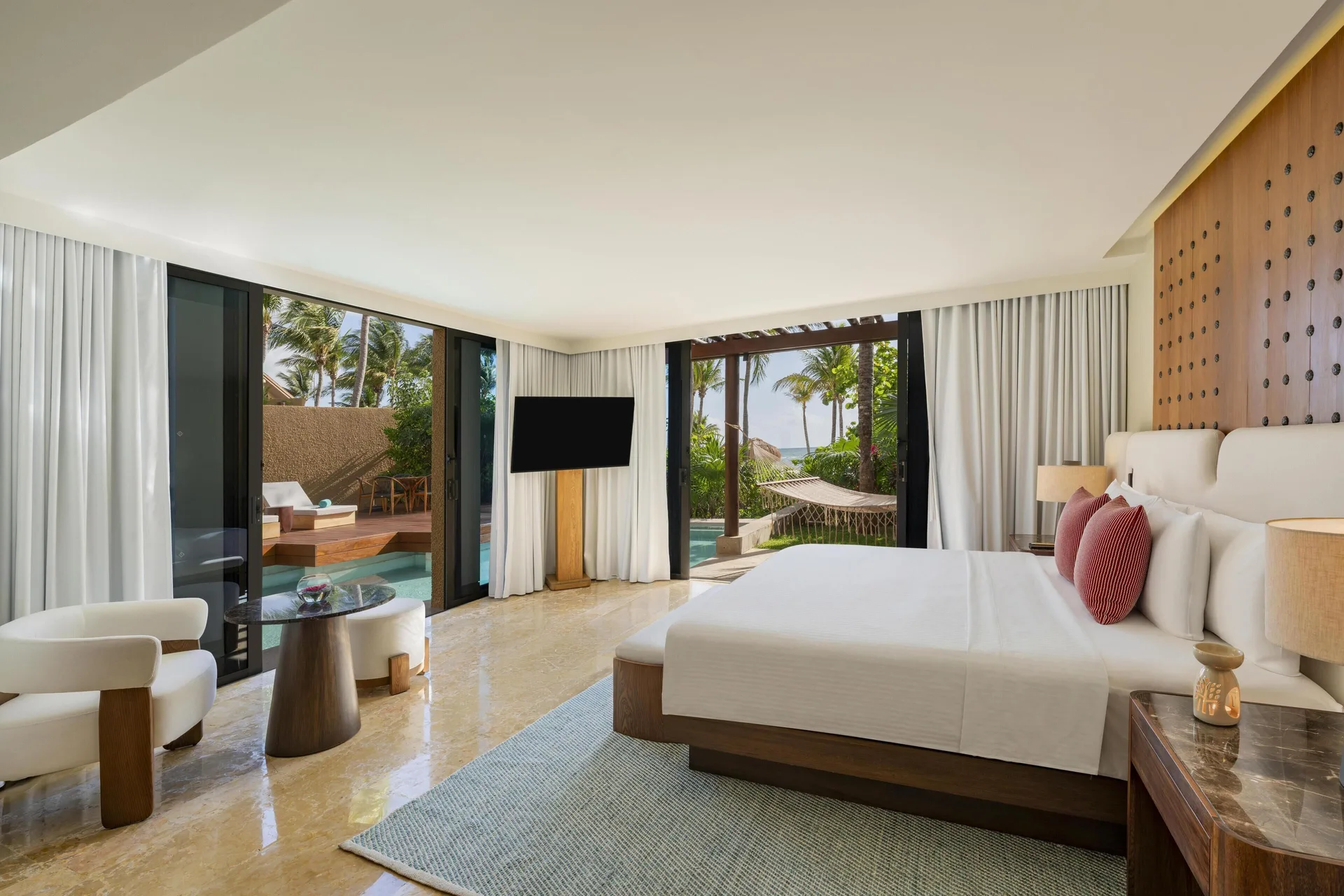 King bedroom with pool terrace and palm views at Banyan Tree Mayakoba.
