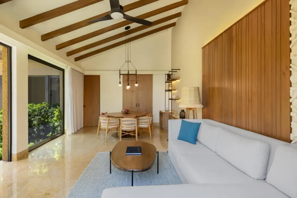Living and dining area with sofa and pitched ceiling at Banyan Tree Mayakoba.