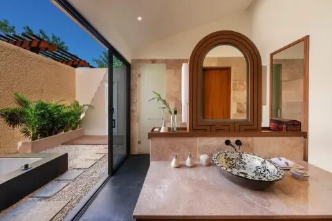 Serenity Pool Villa bathroom at Banyan Tree Mayakoba with vanity, decorative basin, mirror, and outdoor shower area.