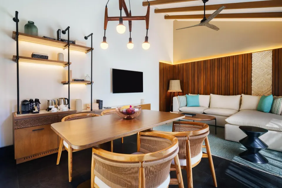 Serenity Pool Villa living and dining area at Banyan Tree Mayakoba with sofa, TV, table, and bar shelves.