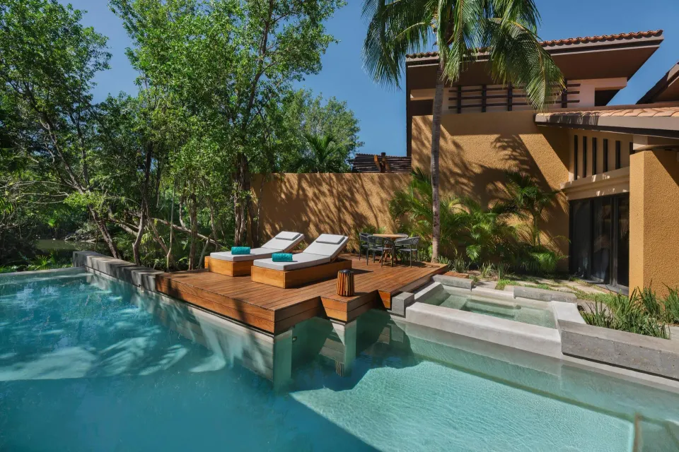 Serenity Pool Villa pool terrace at Banyan Tree Mayakoba with loungers, steps, and a wooded waterway view.