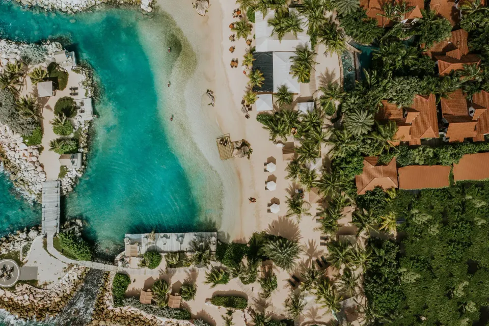 Aerial view of a turquoise lagoon, beach and villas at Baoase Luxury Resort.