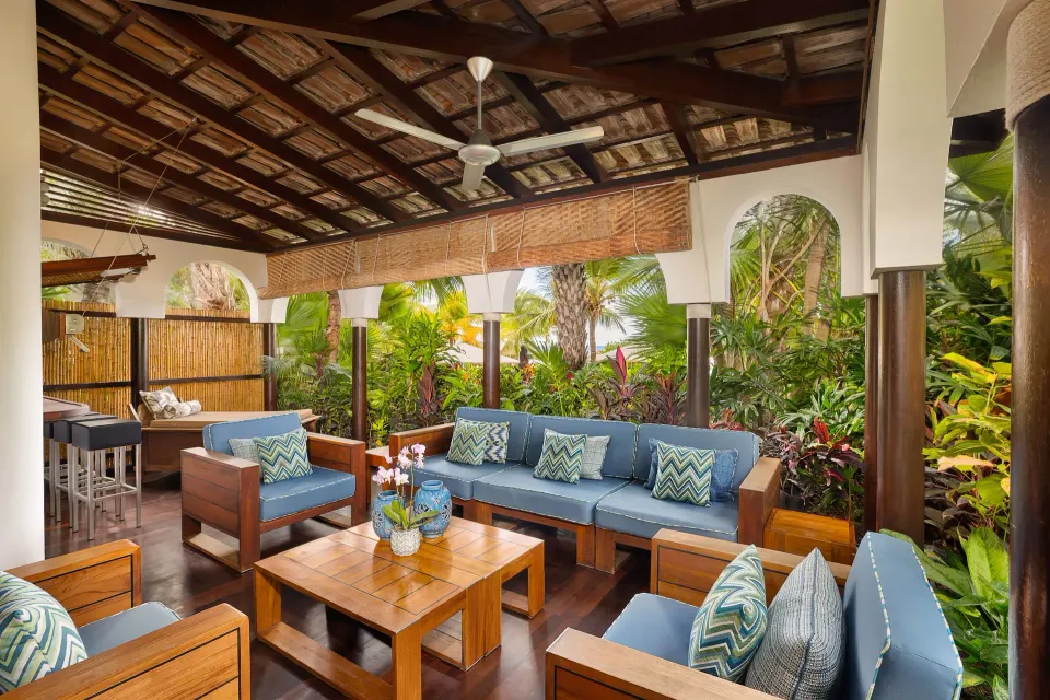 Shaded outdoor seating area with sofas and tropical garden views at Baoase Luxury Resort