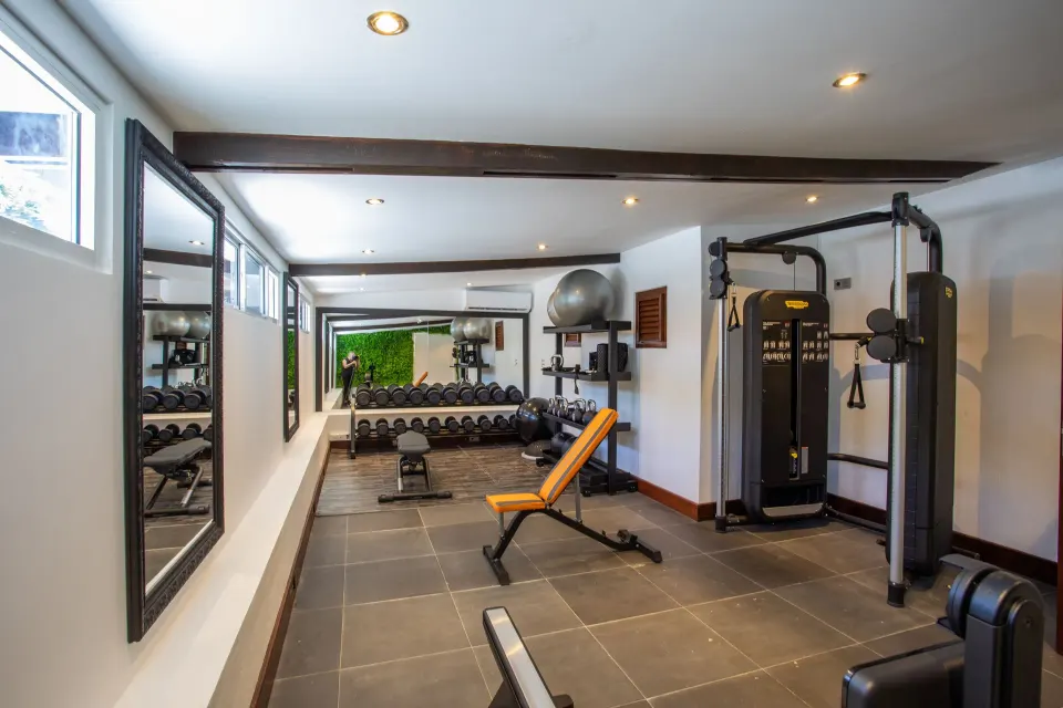 Small fitness room with benches and weight machine at Baoase Luxury Resort.