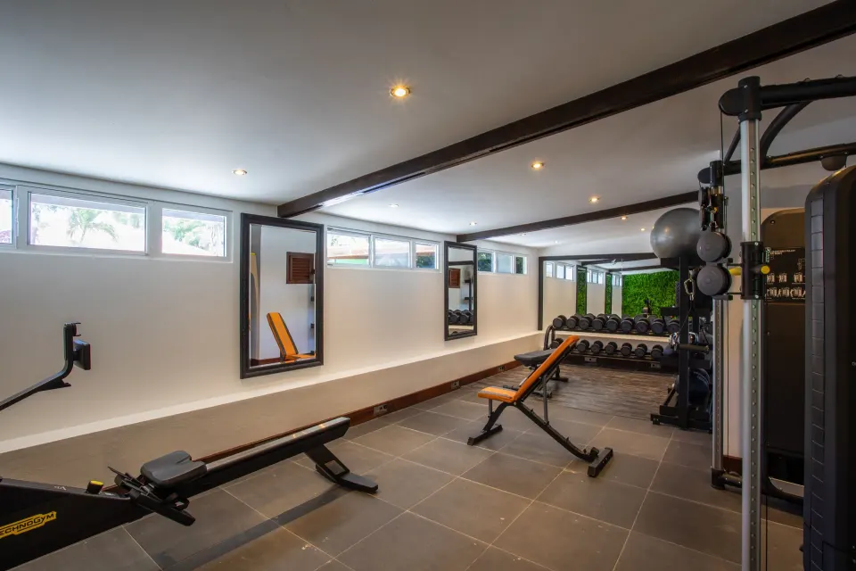Wide view of the resort gym with rowing machine and weight bench at Baoase Luxury Resort.