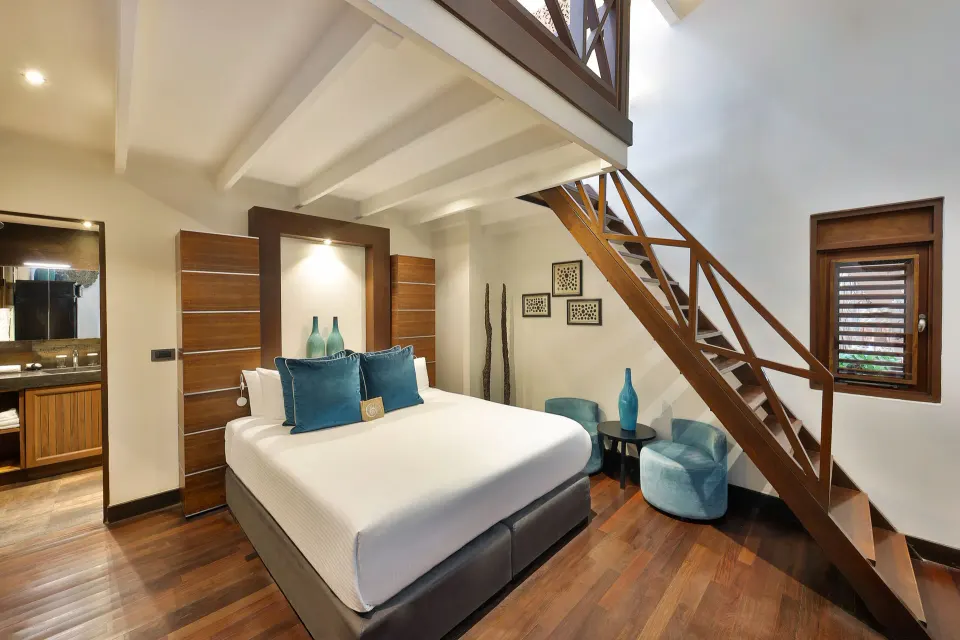 Loft bedroom with staircase, king bed and en-suite area at Baoase Luxury Resort.