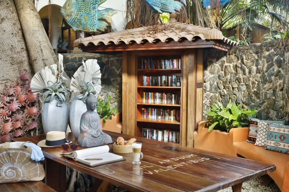Outdoor reading nook and small library shelf in a landscaped corner at Baoase Luxury Resort.