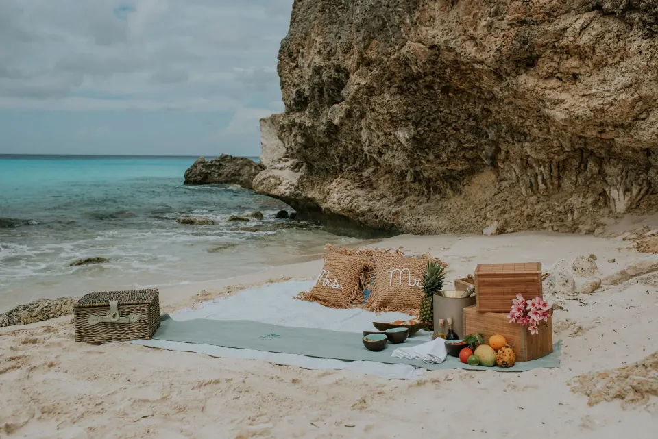 Secluded sandy beach picnic with rock backdrop at Baoase Luxury Resort