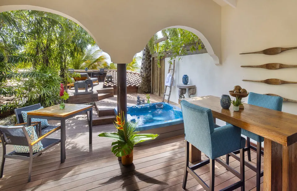Private terrace with dining table and plunge tub at Baoase Luxury Resort