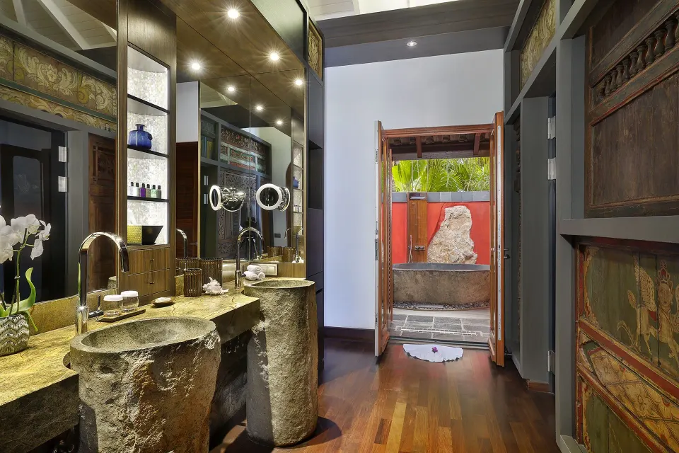 Bathroom interior with double stone basins and open doorway at Baoase Luxury Resort