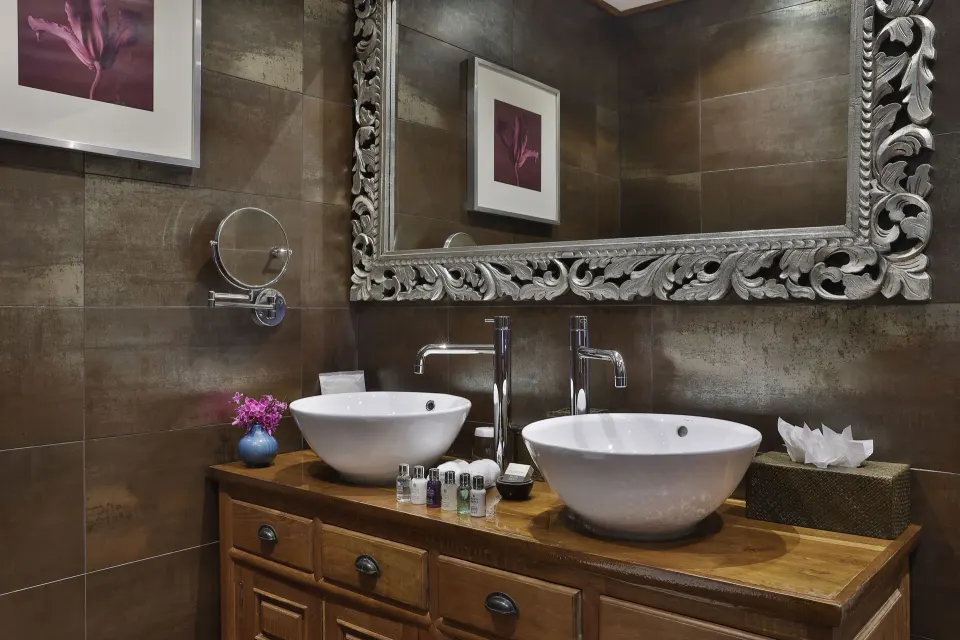 Double sink vanity with ornate mirror in a villa bathroom at Baoase Luxury Resort