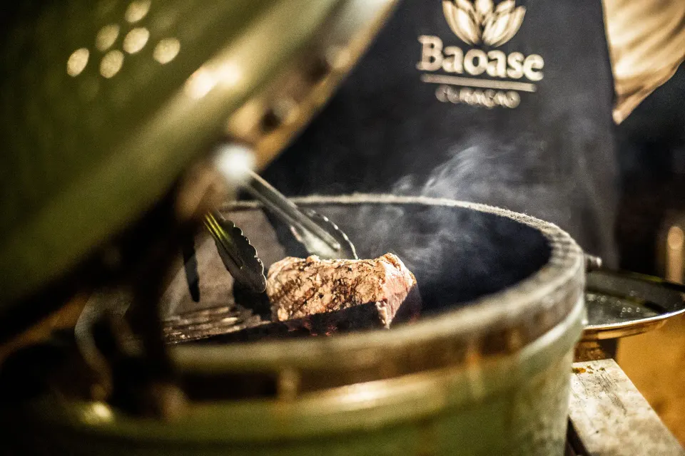 Chef grilling a steak with Baoase apron visible at Baoase Luxury Resort