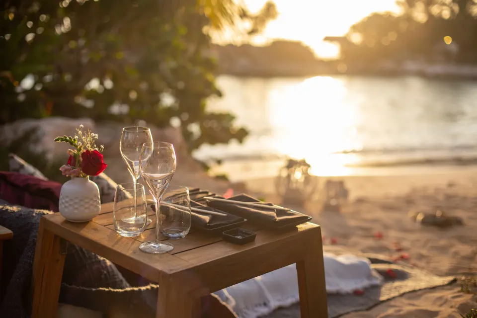 Close-up beach table set for two at sunset at Baoase Luxury Resort
