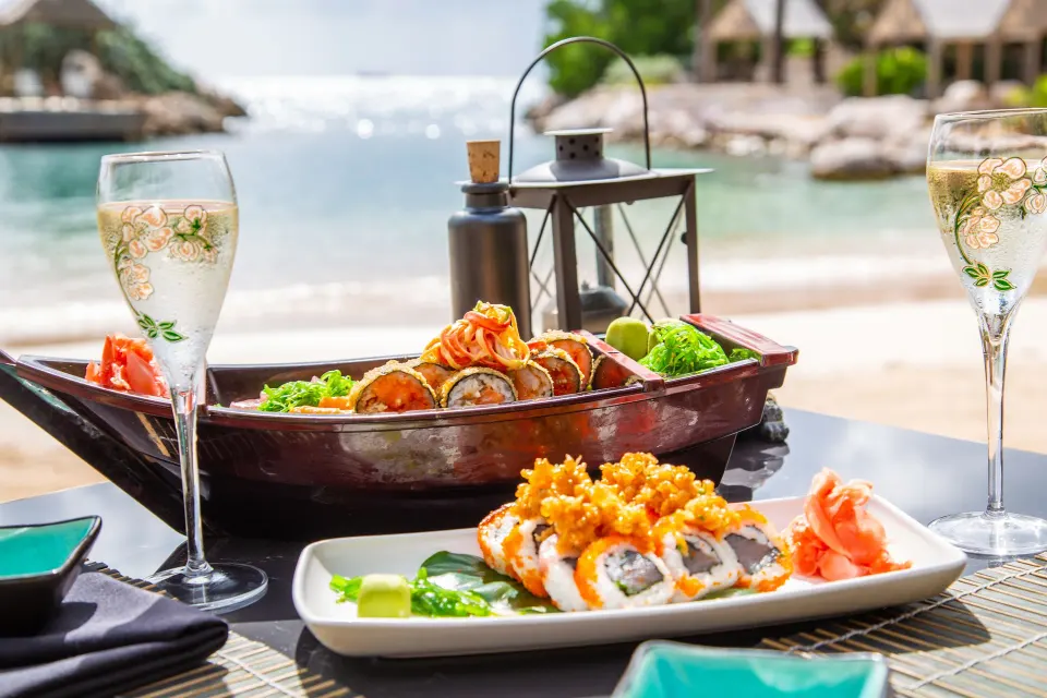 Sushi platter and champagne on a beachfront table at Baoase Luxury Resort