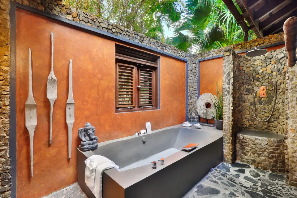 Private outdoor stone bathtub and shower in Banyan Tree Room at Baoase Luxury Resort