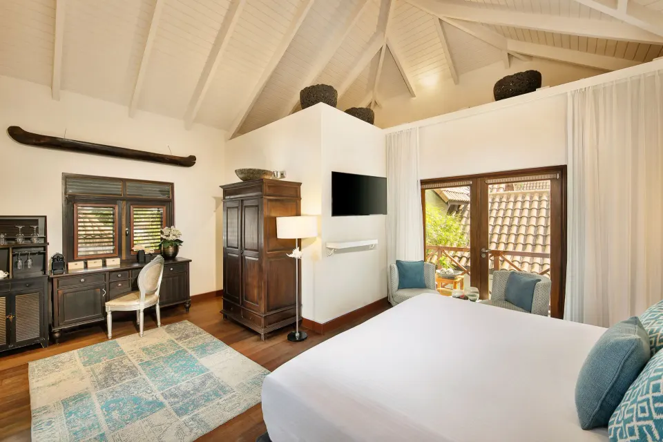 Colonial Room interior showing king bed, wooden wardrobe and balcony view at Baoase Luxury Resort