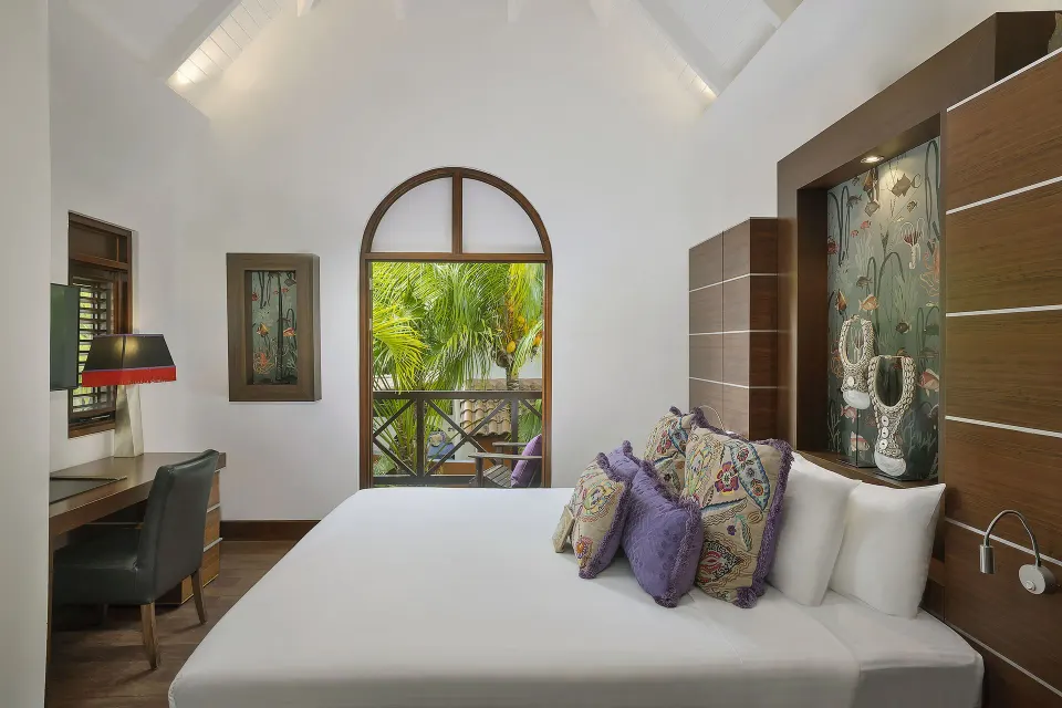 Private Pool Villa king bed with decorative pillows and arched window at Baoase Luxury Resort