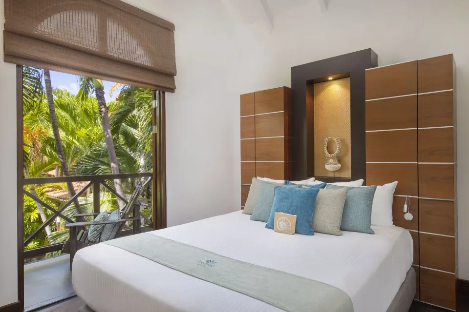 King bed in a Tropical Pool Villa bedroom with balcony and palm views at Baoase Luxury Resort