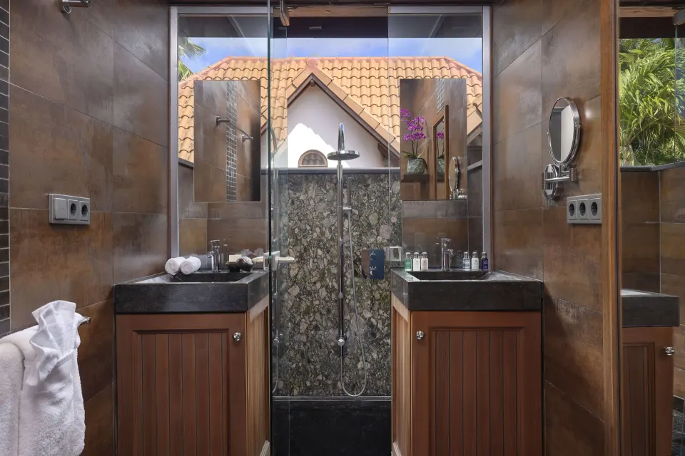 Shower and dual sinks in a Tropical Pool Villa bathroom with garden view at Baoase Luxury Resort