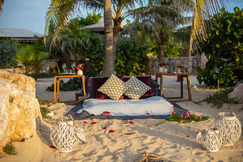 Romantic beach setup with cushions and candles at Baoase Luxury Resort