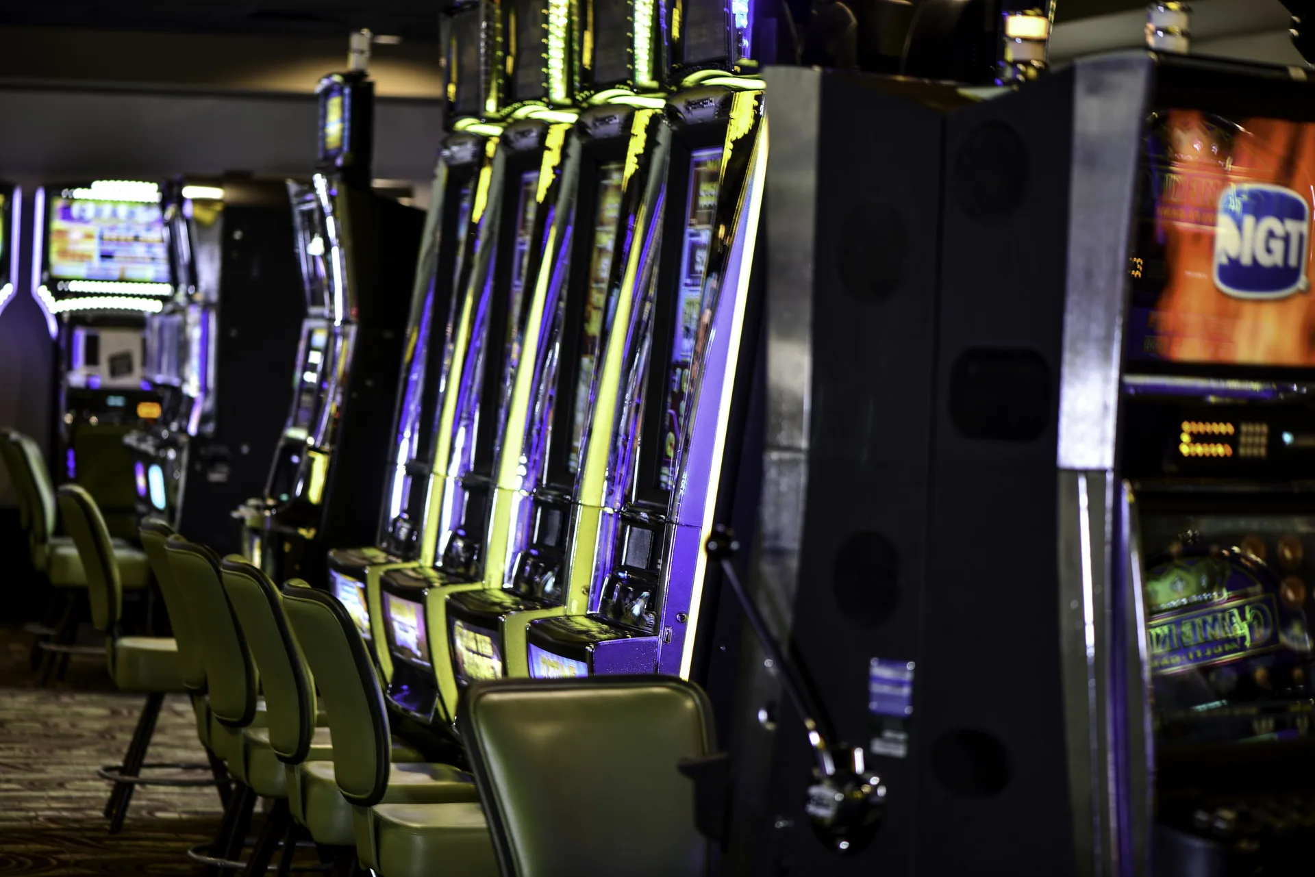 Close view of slot machines with stools in the casino at Barceló Aruba.