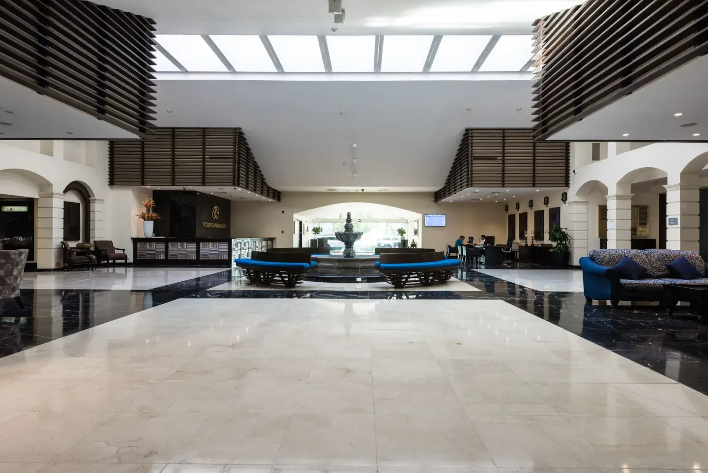 Wide lobby with fountain, skylight, and reception areas at Barceló Aruba.