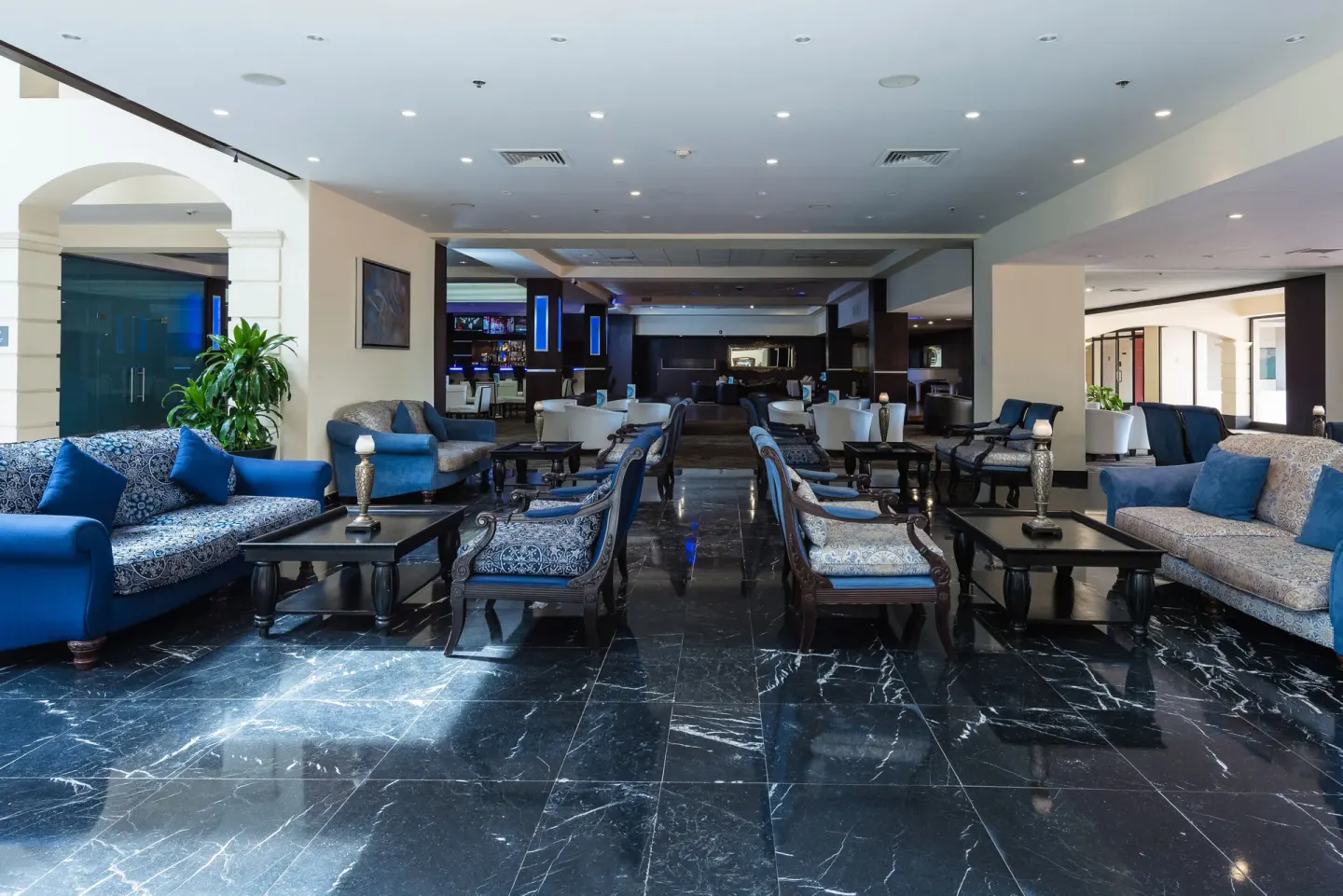 Blue sofas, patterned armchairs, and tables in the lobby lounge at Barceló Aruba.