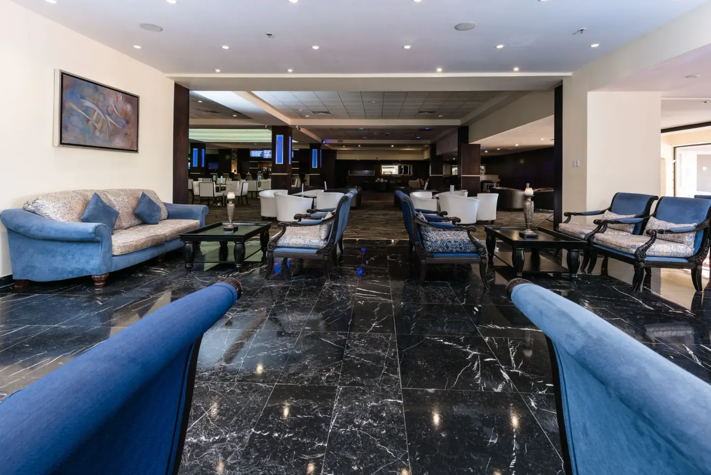 Lobby lounge seating with blue sofas and black marble floors at Barceló Aruba.