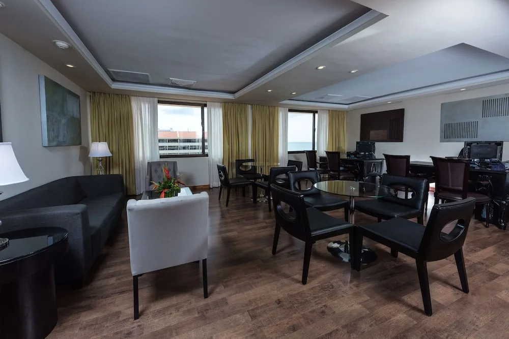 Spacious lounge with seating, desks, and ocean-facing windows at Barceló Aruba.