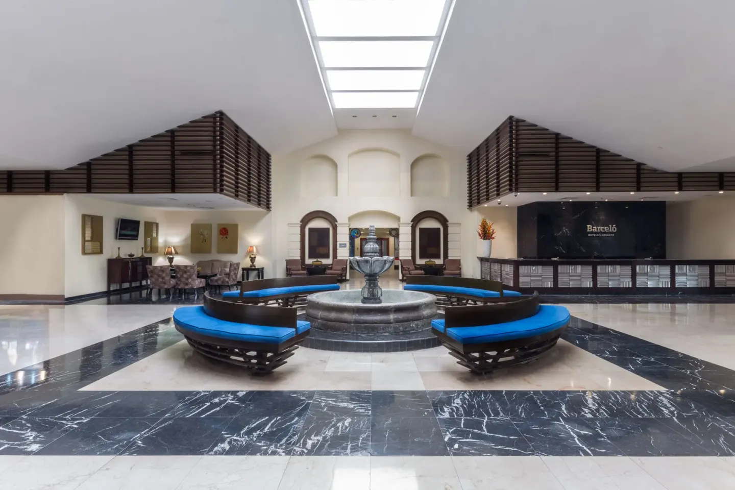 Reception lobby with central fountain and Barceló sign at Barceló Aruba.