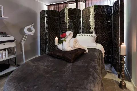 Spa treatment bed with towels, candles, and woven screen at Barceló Aruba.
