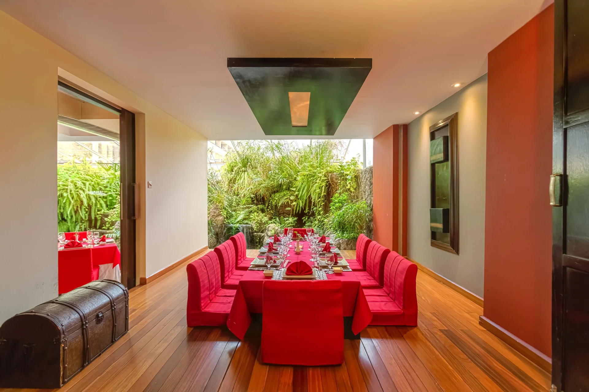 A long red-draped dining table is set in a private room at Barceló Aruba.