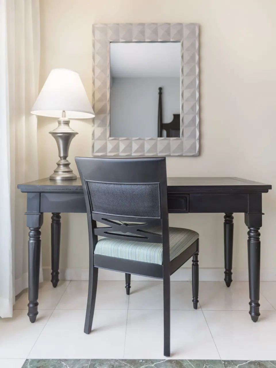 Deluxe Room writing desk with lamp, chair, and wall mirror at Barceló Aruba.