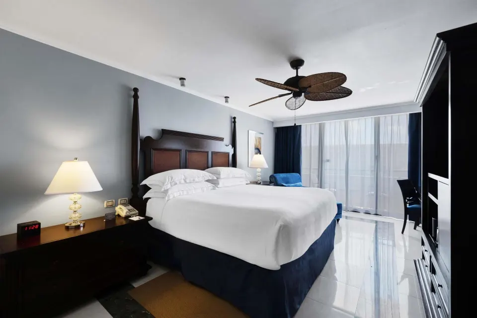 Luxury Ocean View Royal Level room with king bed and sheer balcony curtains at Barceló Aruba.
