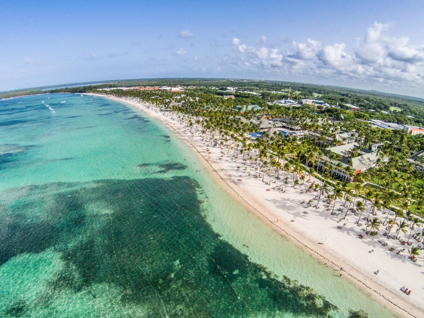 Aerial view of the beach, palms, and turquoise water at Barceló Bávaro Beach.