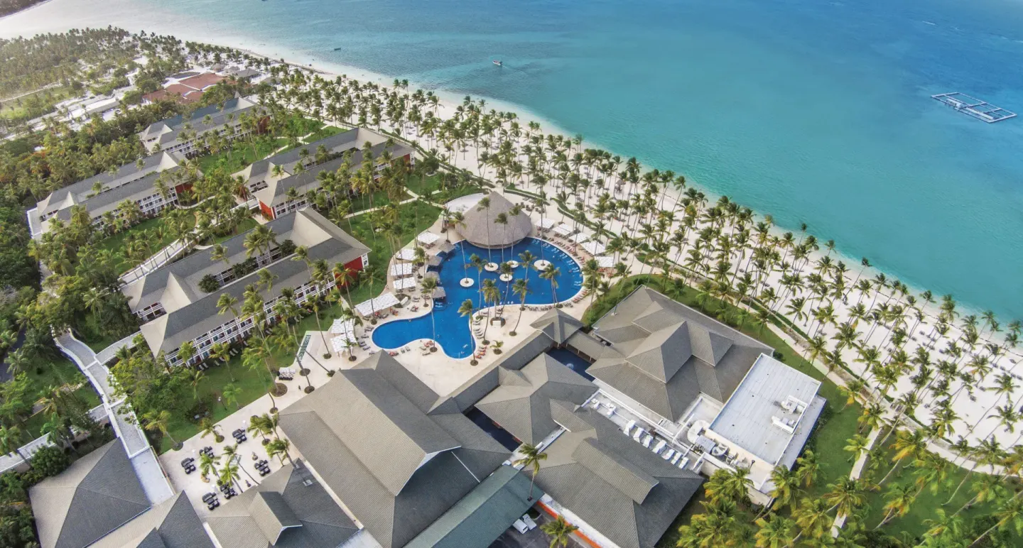 Aerial view of the pool, beachfront palms, and ocean at Barceló Bávaro Beach.
