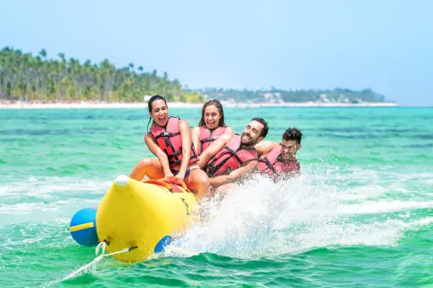 Guests ride a yellow banana boat through the surf at Barceló Bávaro Beach.