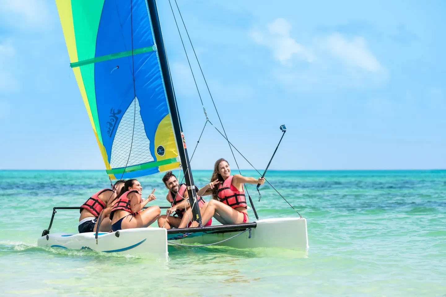 Guests sail a small catamaran on turquoise water at Barceló Bávaro Beach.