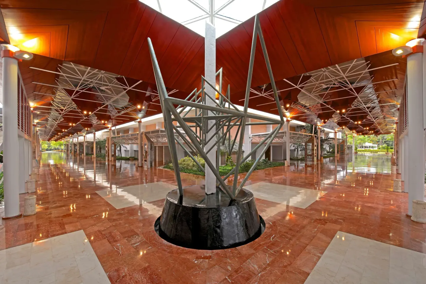 Covered resort walkway with sculpture and polished floors at Barceló Bávaro Beach.