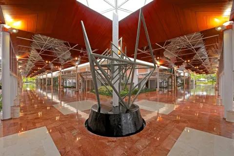Covered resort walkway with sculpture and polished floors at Barceló Bávaro Beach.