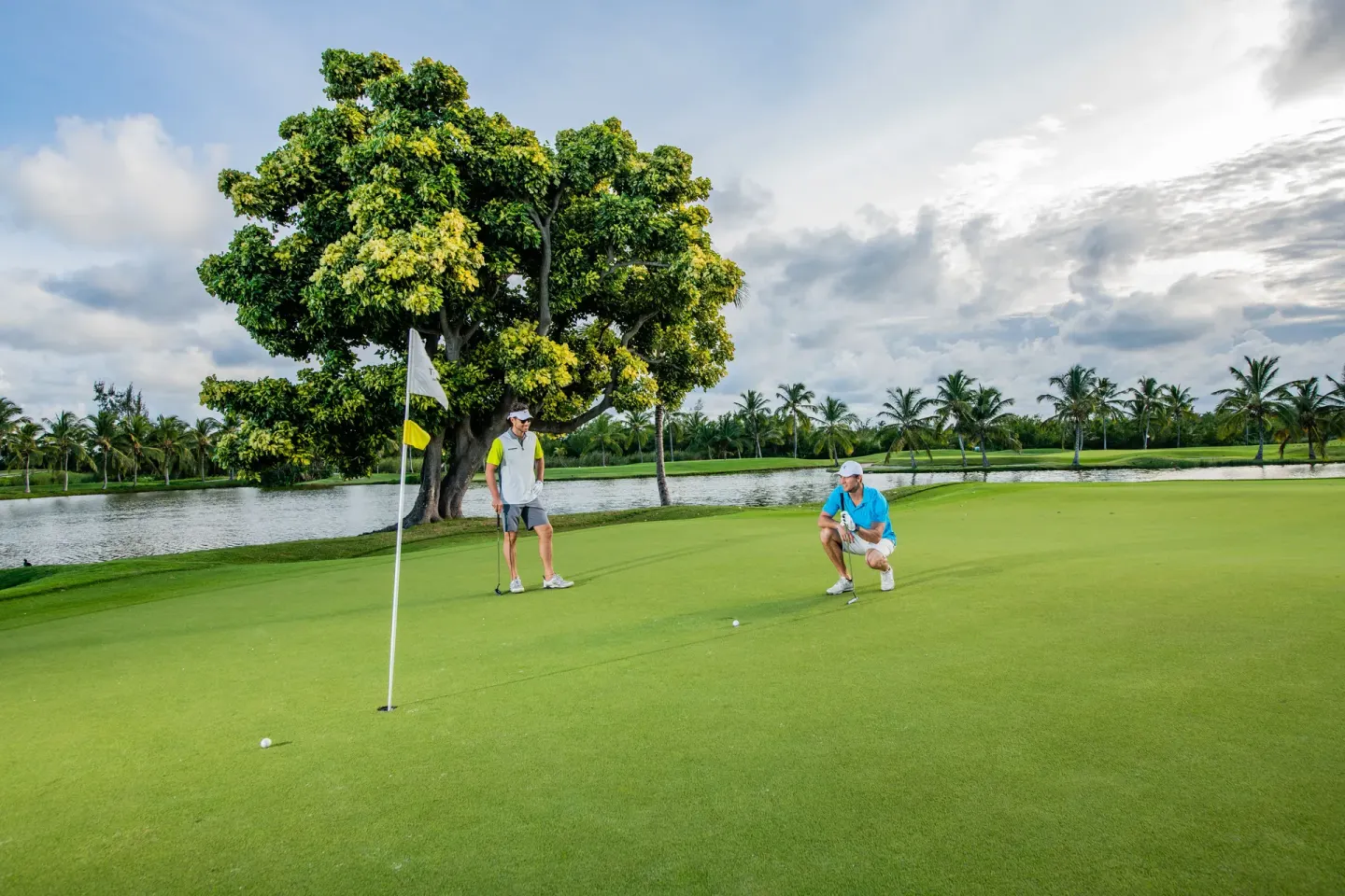 Golfers line up putts on a green near a lagoon at Barceló Bávaro Beach.