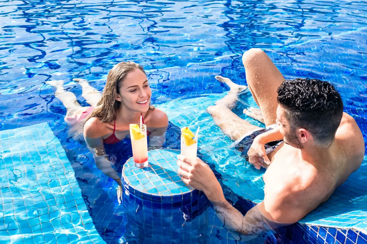 Couple with tropical drinks at an in-pool table at Barceló Bávaro Beach.