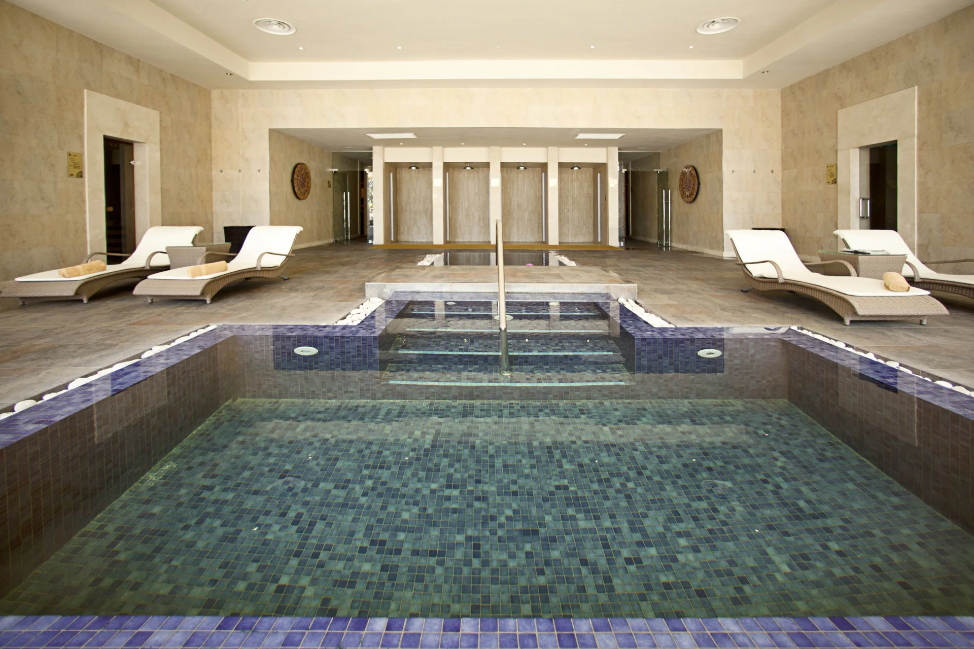 Indoor spa pool with loungers and tiled steps at Barceló Bávaro Beach.