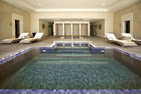 Tiled indoor spa pool with loungers at Barceló Bávaro Palace.